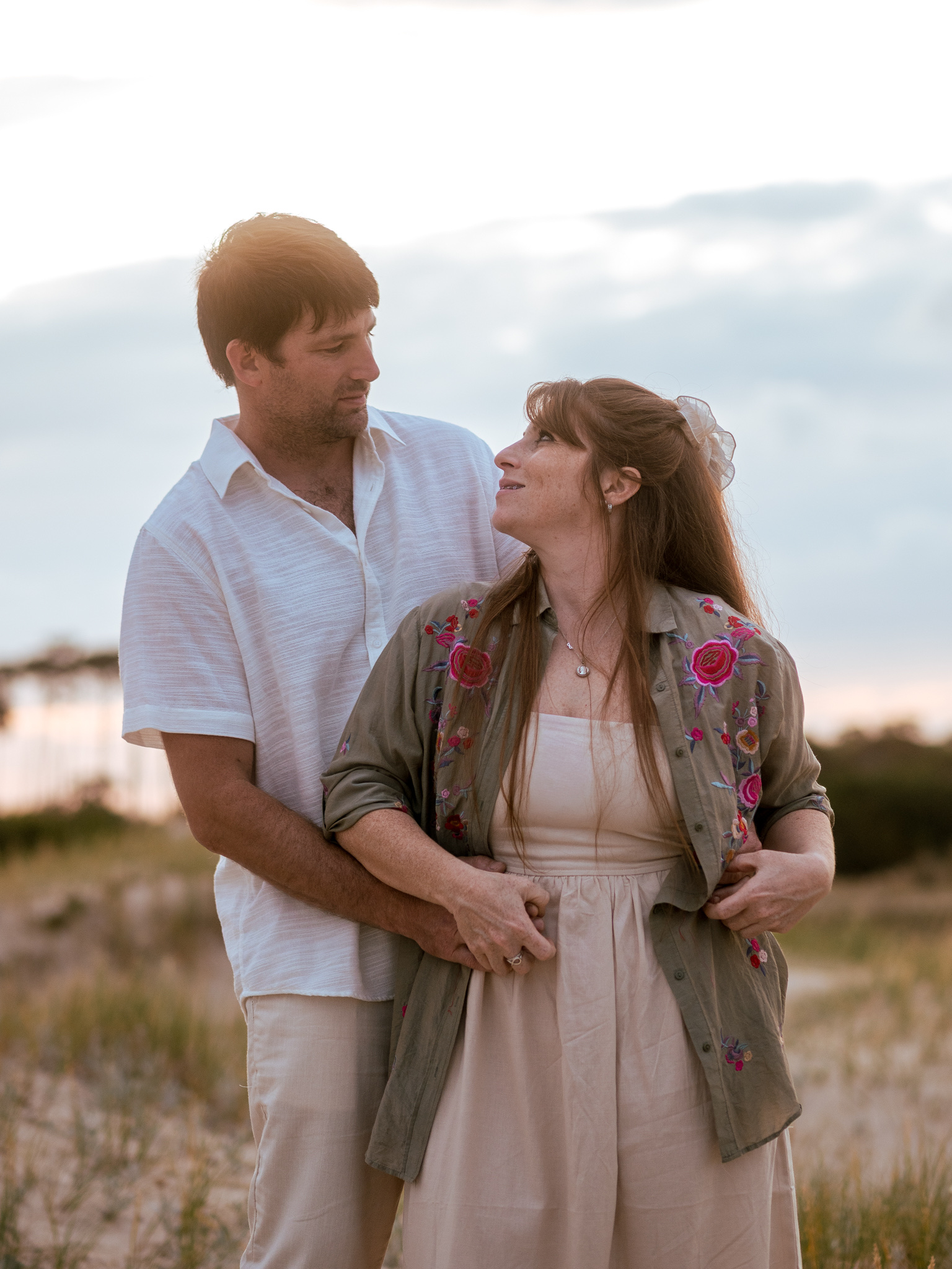 Abrazo de novios entre las dunas al atardecer
